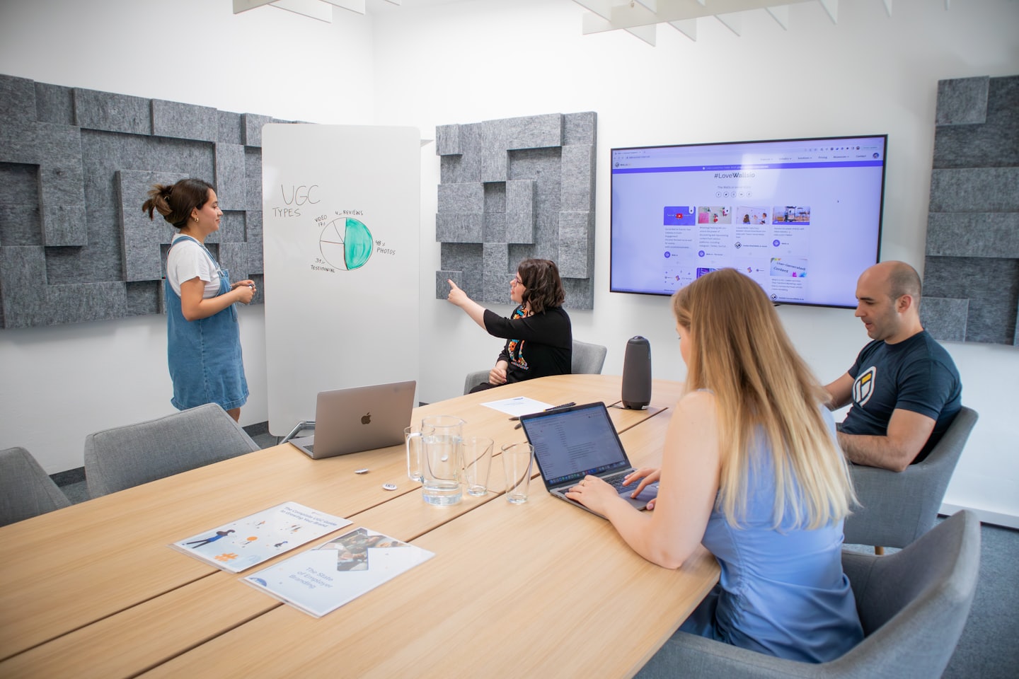 Team collaborating in a modern office meeting room with a presentation.